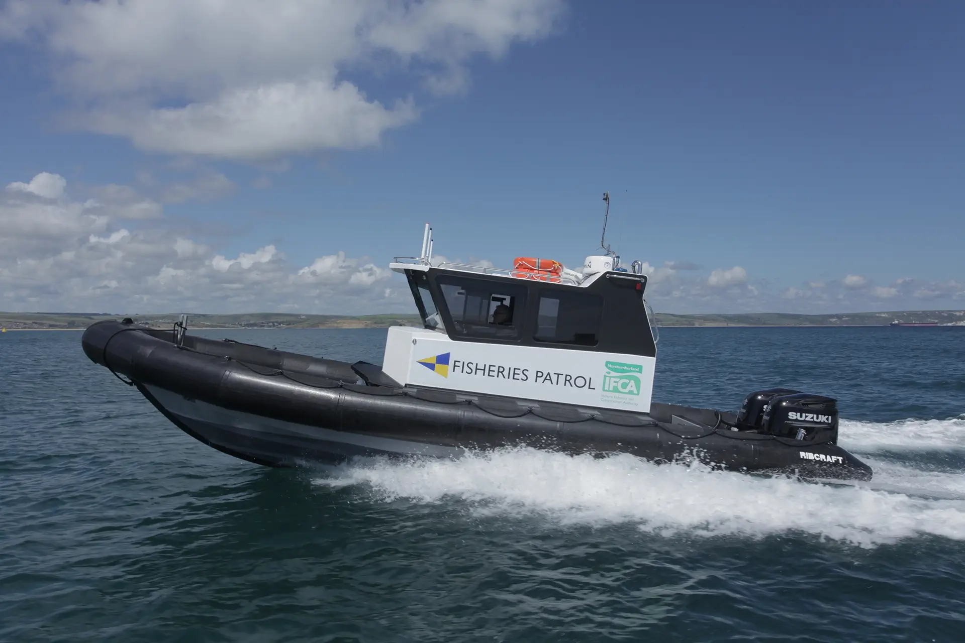 NIFCA fisheries patrol boat, black and white with NIFCA logo on the side, at sea.