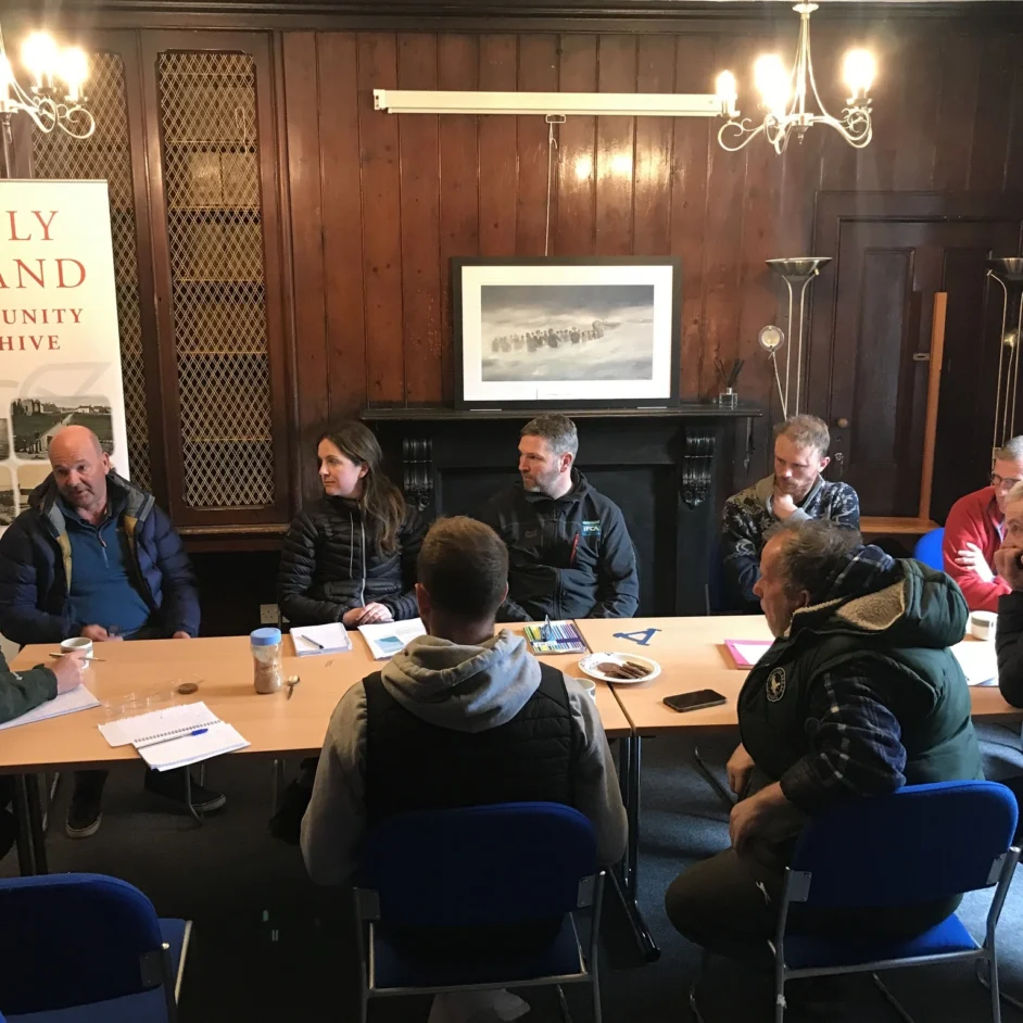 Group of fishers and NIFCA representatives sat round table.