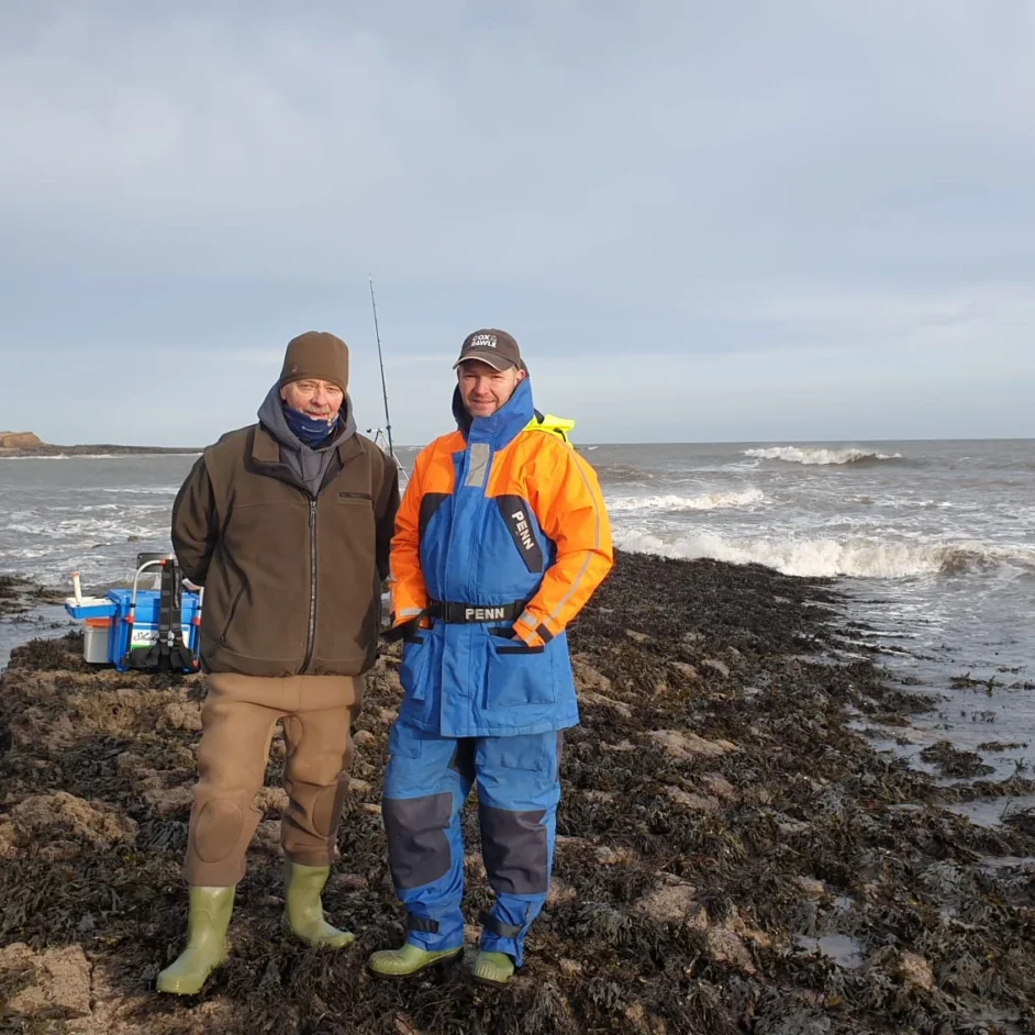 NIFCA Chief Officer and sea angler pictured on rocky shore.